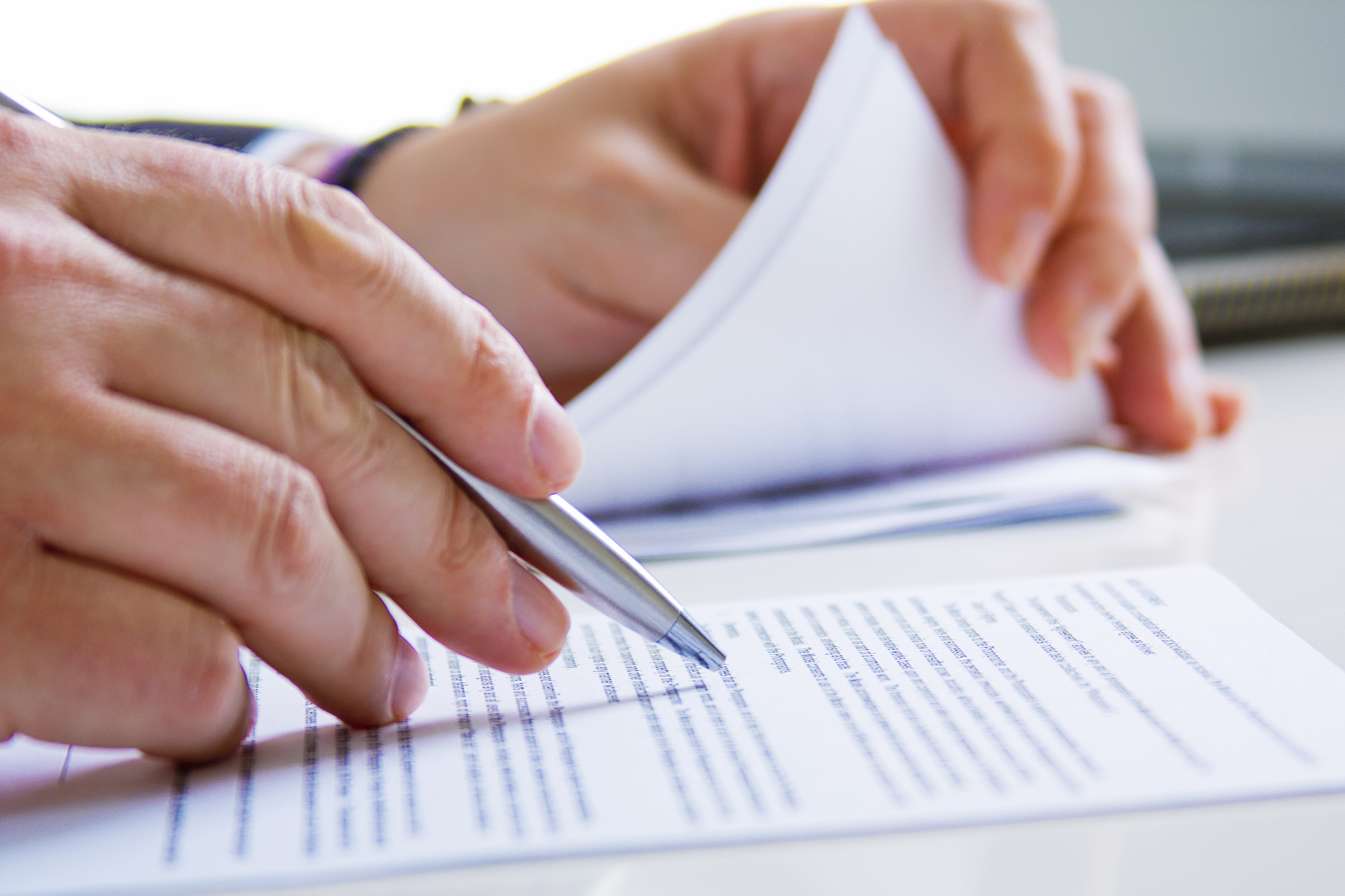 Hands of Business man in dark suit writing in his datebook Legal translations for contracts, official documents and business legal processes